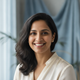 Portrait of a smiling South Asian woman, late 20s to early 30s, with a warm and trustworthy expression.